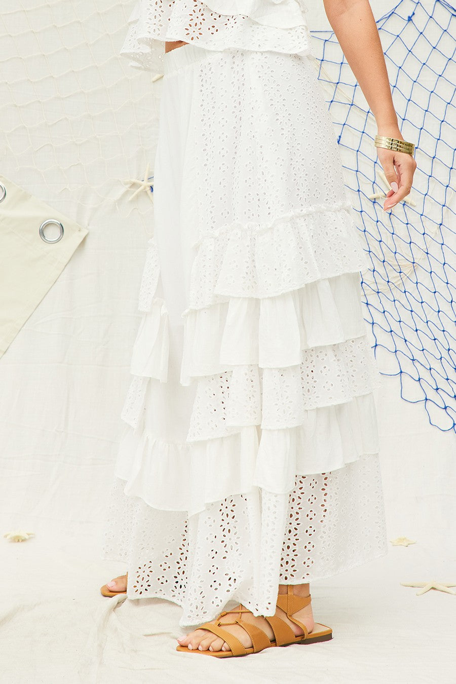 Breezy and feminine, this white tiered maxi skirt features delicate eyelet lace panels and cascading ruffle layers for a romantic, beachy vibe. Designed with a flowy silhouette, it's perfect for vacations, brunch, or effortlessly chic summer looks.