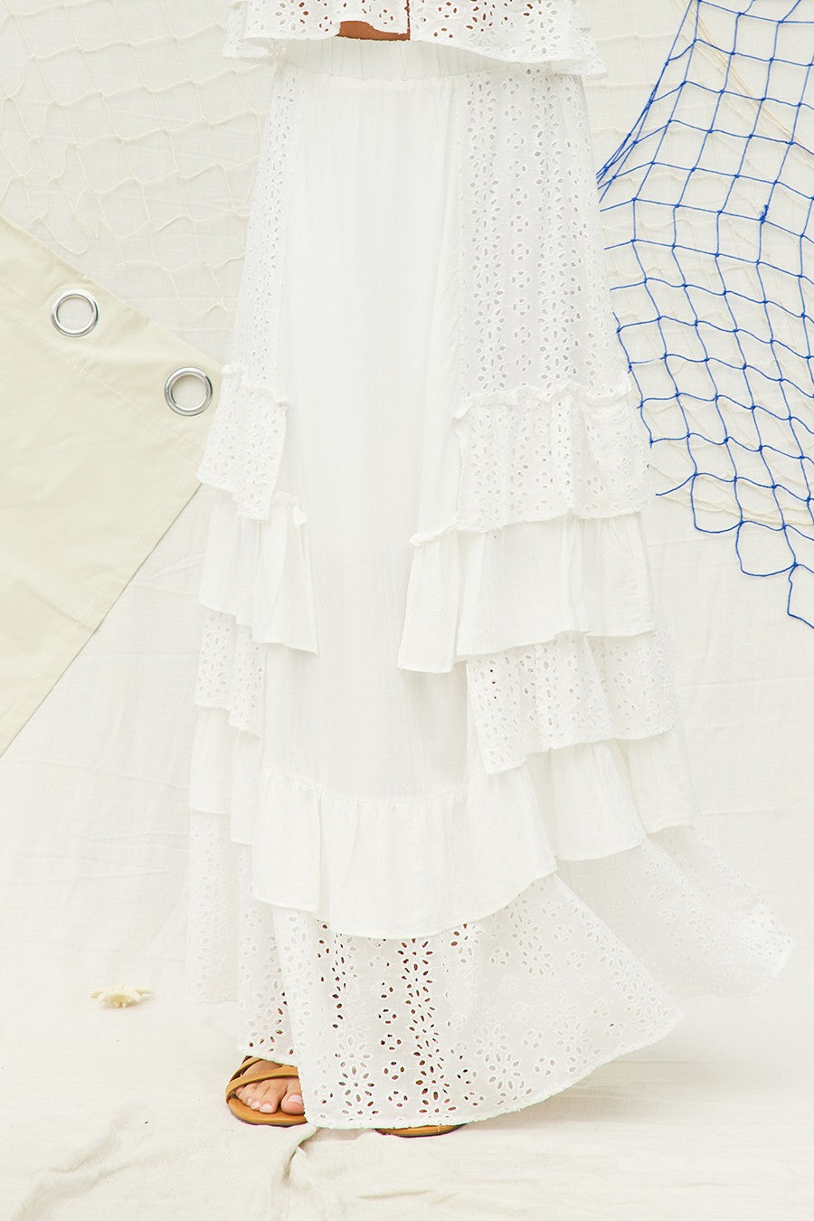 Breezy and feminine, this white tiered maxi skirt features delicate eyelet lace panels and cascading ruffle layers for a romantic, beachy vibe. Designed with a flowy silhouette, it's perfect for vacations, brunch, or effortlessly chic summer looks.