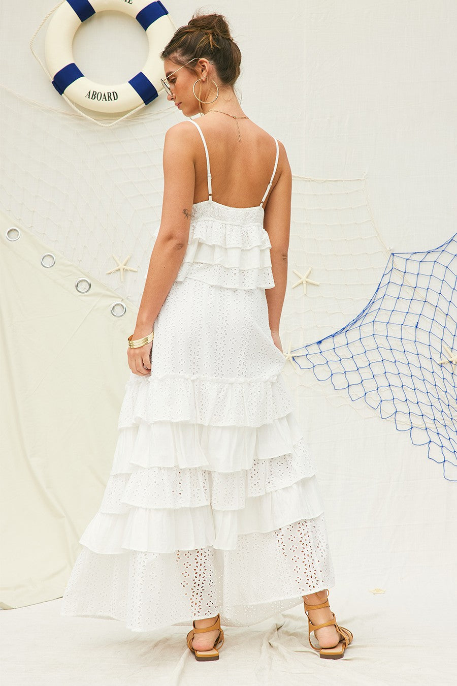 Feminine and breezy, this white eyelet lace crop top features tiered ruffle layers, a delicate V-neckline with lace trim, and adjustable spaghetti straps for a customizable fit. Perfect for pairing with skirts, shorts, or denim for effortless summer style.