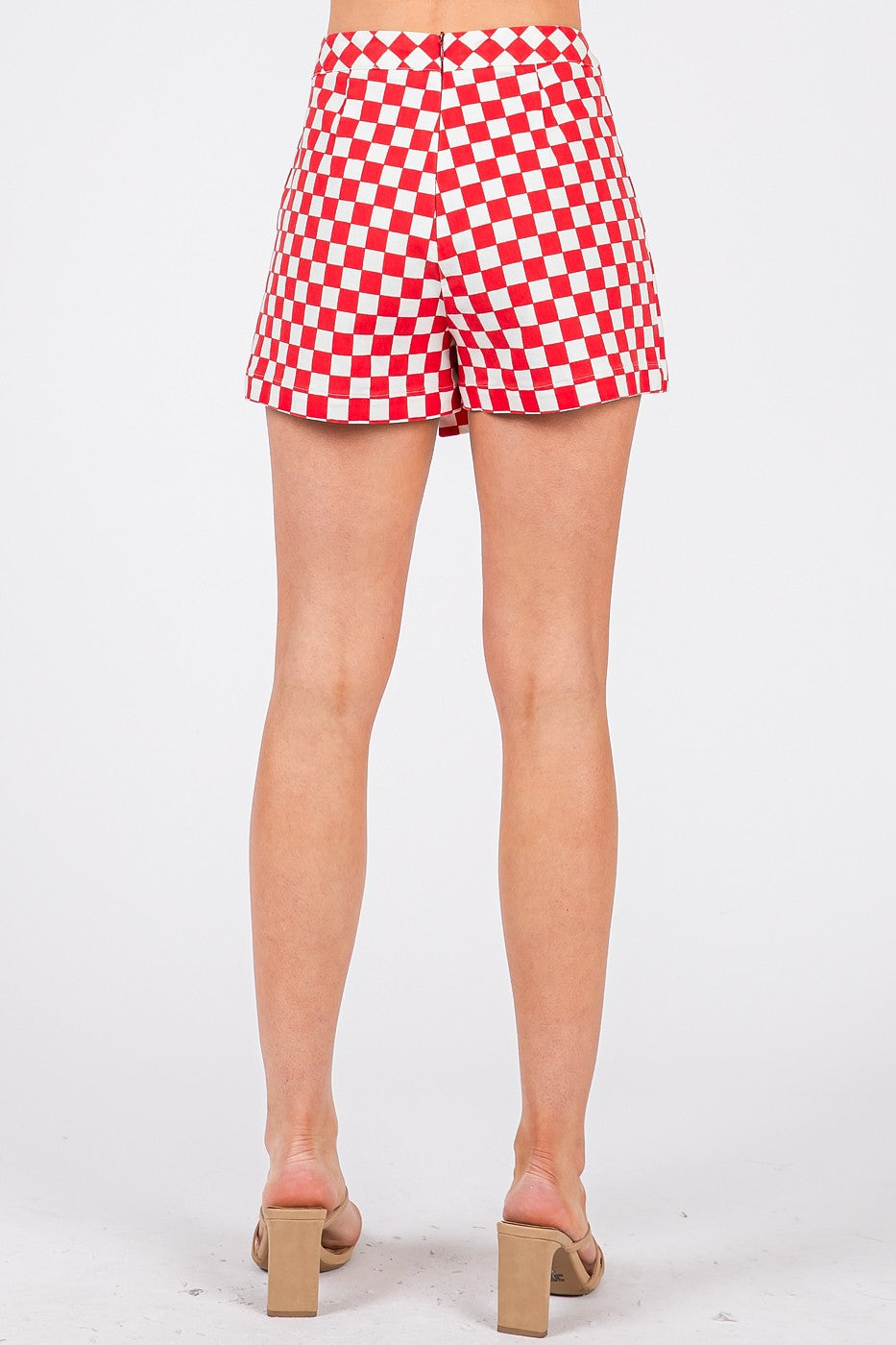 Red and white checkered shorts worn by a person on a white background