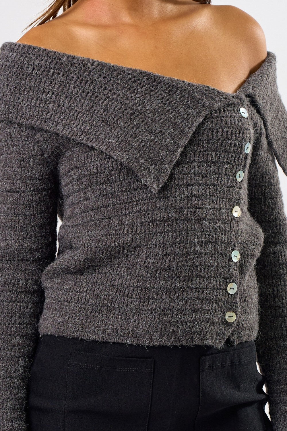 Gray off-shoulder sweater with button details on a plain background