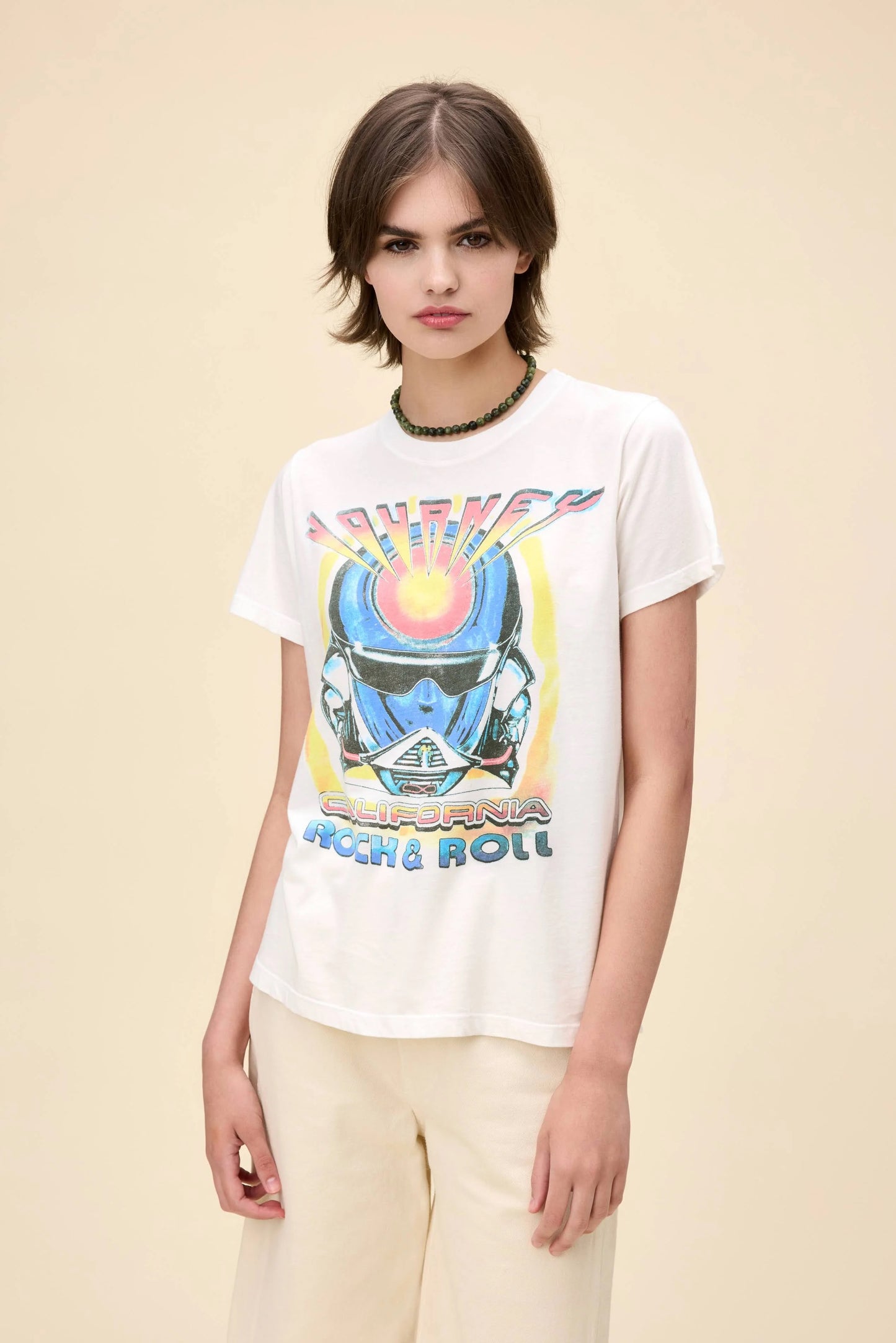 Vintage-inspired Journey California Rock & Roll graphic tee, featuring a bold retro helmet design on the front with colorful gradient lettering. The back showcases a 1983 Los Angeles concert graphic with palm trees and a sunset aesthetic. Designed in a relaxed fit, this lightweight tee is perfect for music lovers and casual streetwear.