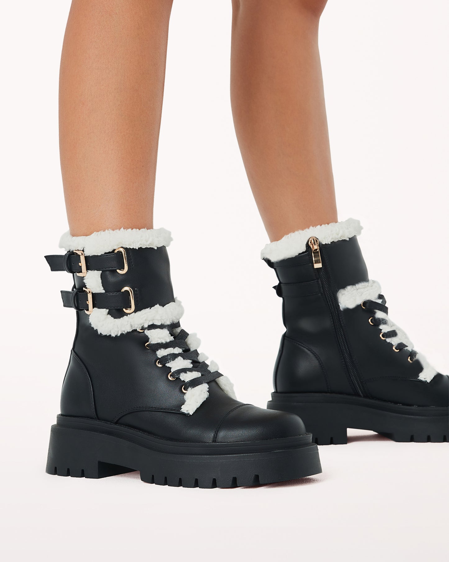 Womens Black Combat Boot With Shearling Lining and a double buckle.feature at the ankle. Gold detailing and zips down the inner side.
