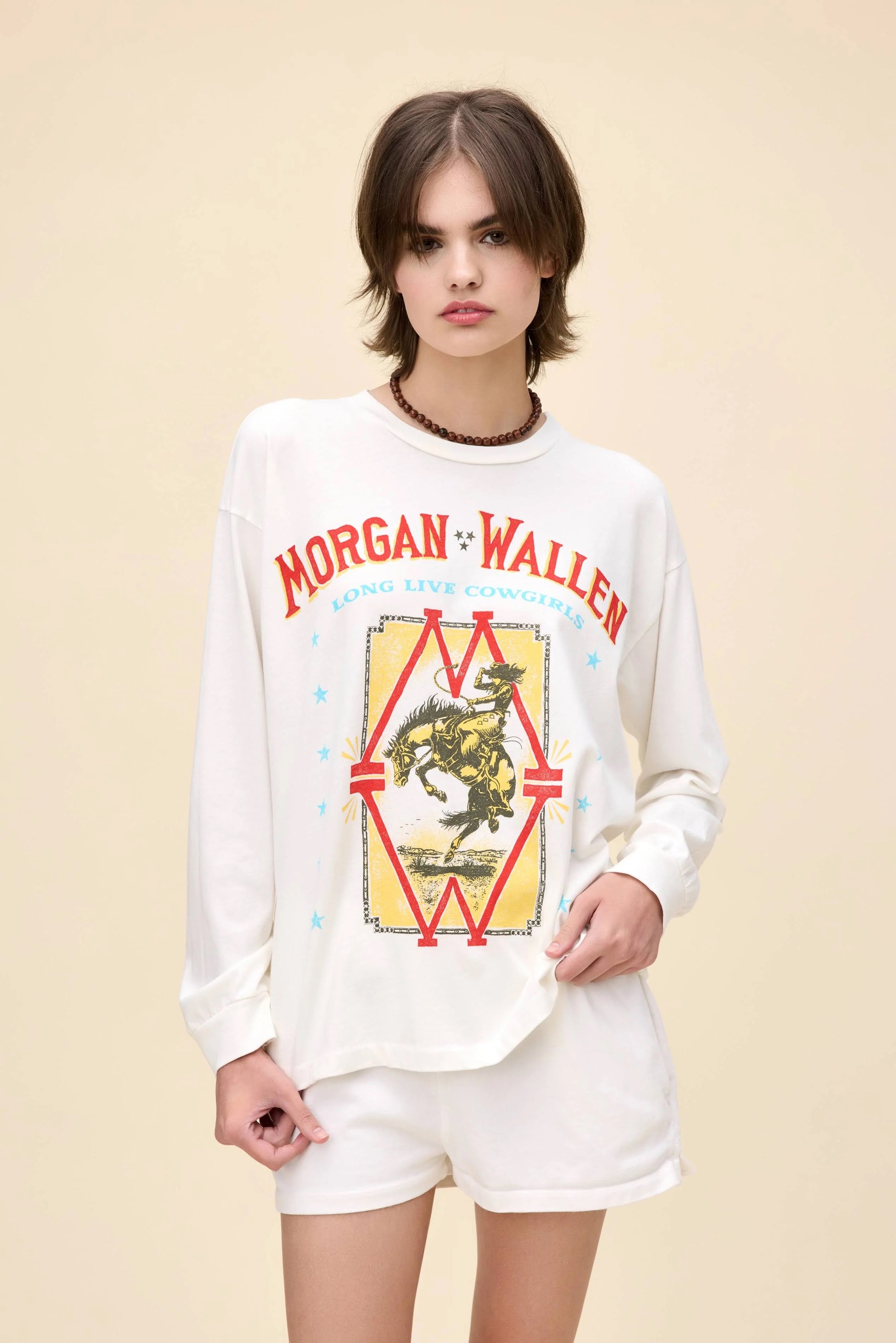White Morgan Wallen Long Live Cowgirls graphic tee, featuring a vintage-inspired bronco riding print, bold red and blue lettering, and Western-style star details. Designed in a relaxed, oversized fit, this long-sleeve shirt is perfect for country music lovers and casual cowboy-inspired outfits.