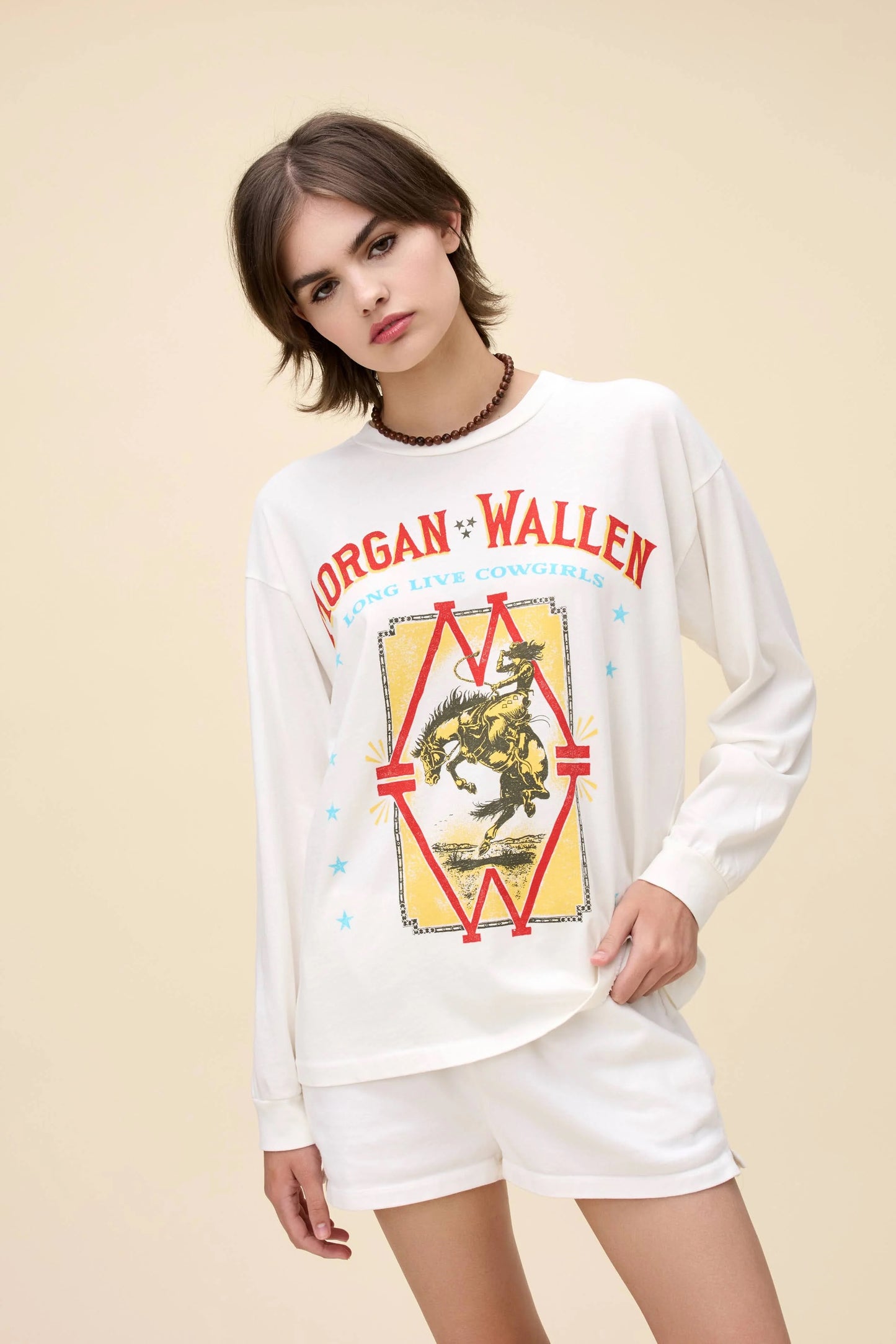 White Morgan Wallen Long Live Cowgirls graphic tee, featuring a vintage-inspired bronco riding print, bold red and blue lettering, and Western-style star details. Designed in a relaxed, oversized fit, this long-sleeve shirt is perfect for country music lovers and casual cowboy-inspired outfits.