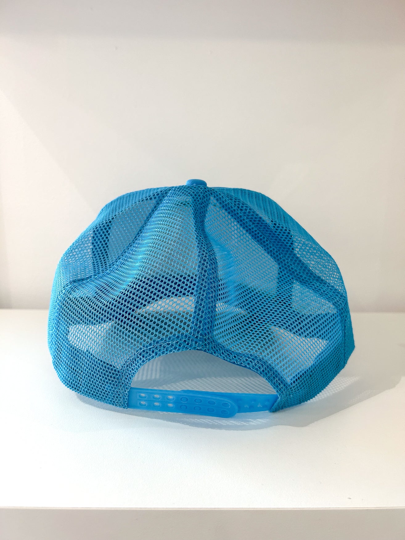 Adjustable snapback closure on trucker hat and breathable mesh