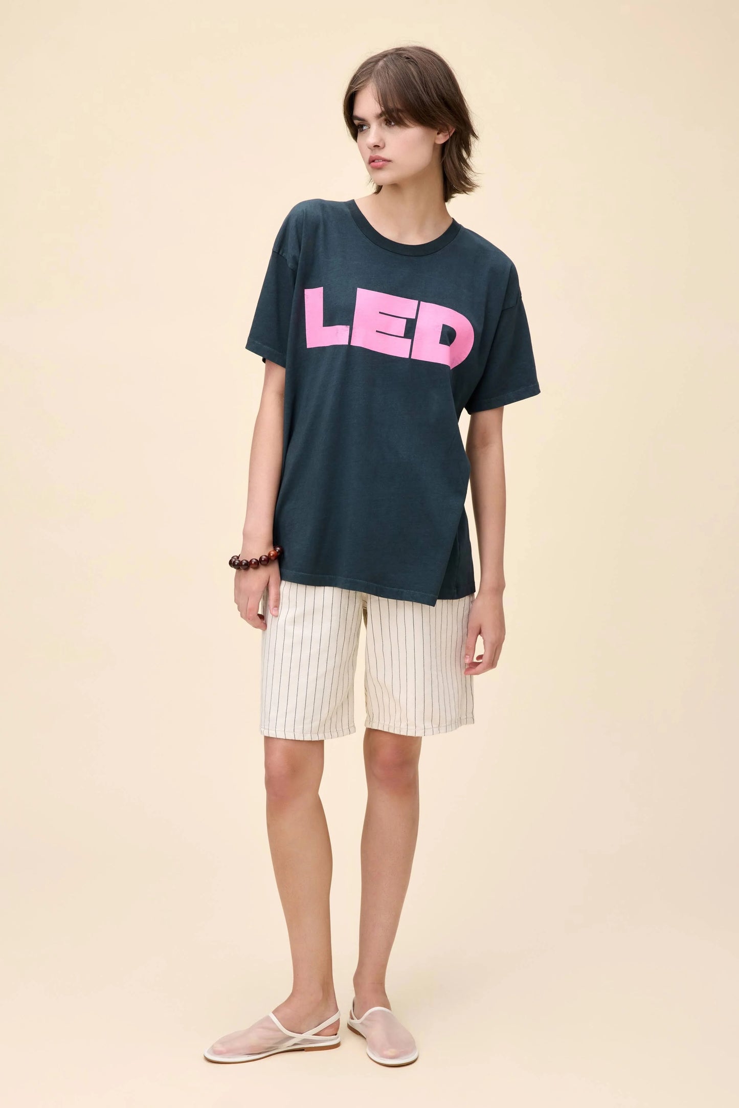 Model wearing a vintage-style Led Zeppelin oversized black t-shirt with pink "LED" print on the front.