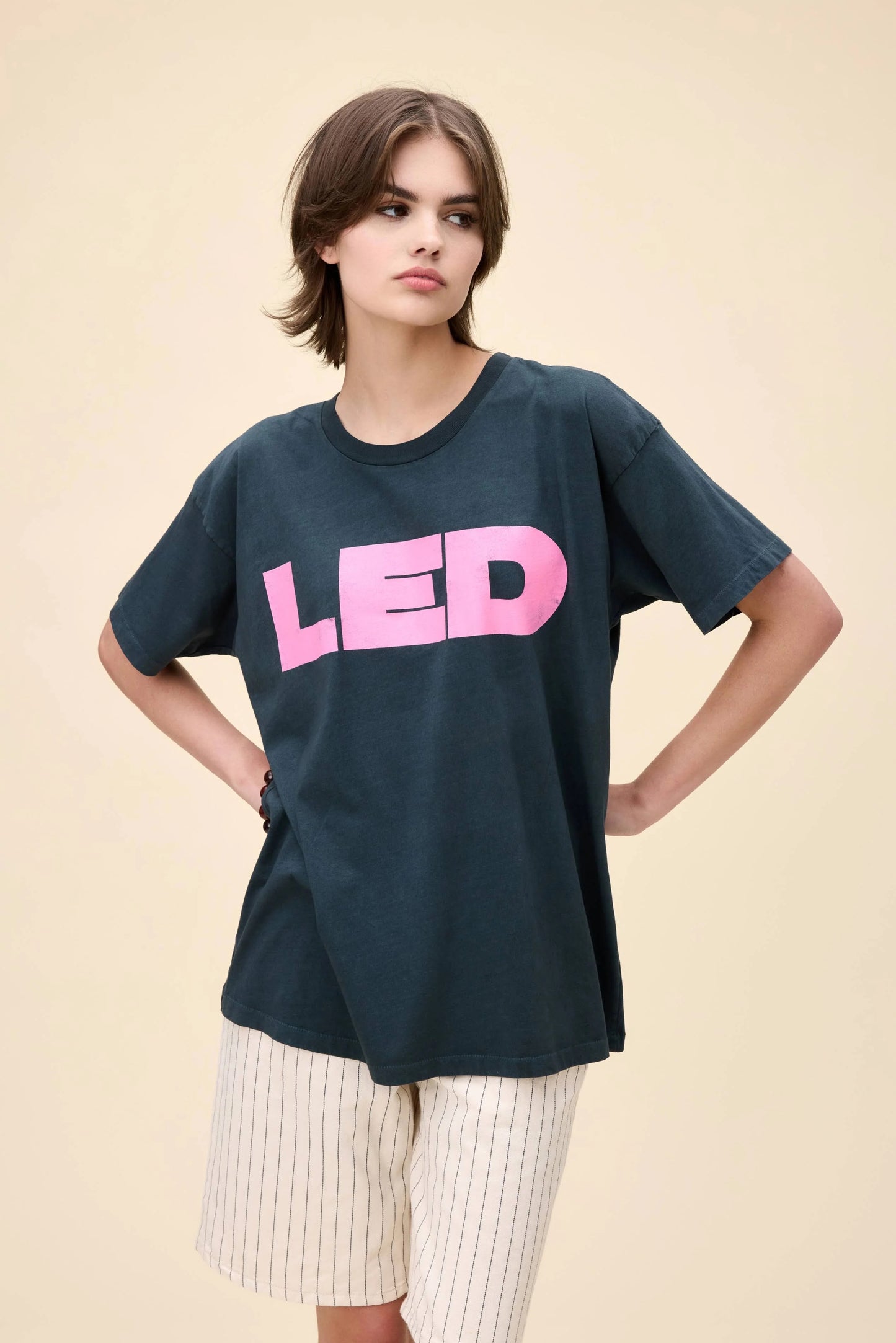 Model wearing a vintage-style Led Zeppelin oversized black t-shirt with pink "LED" print on the front.