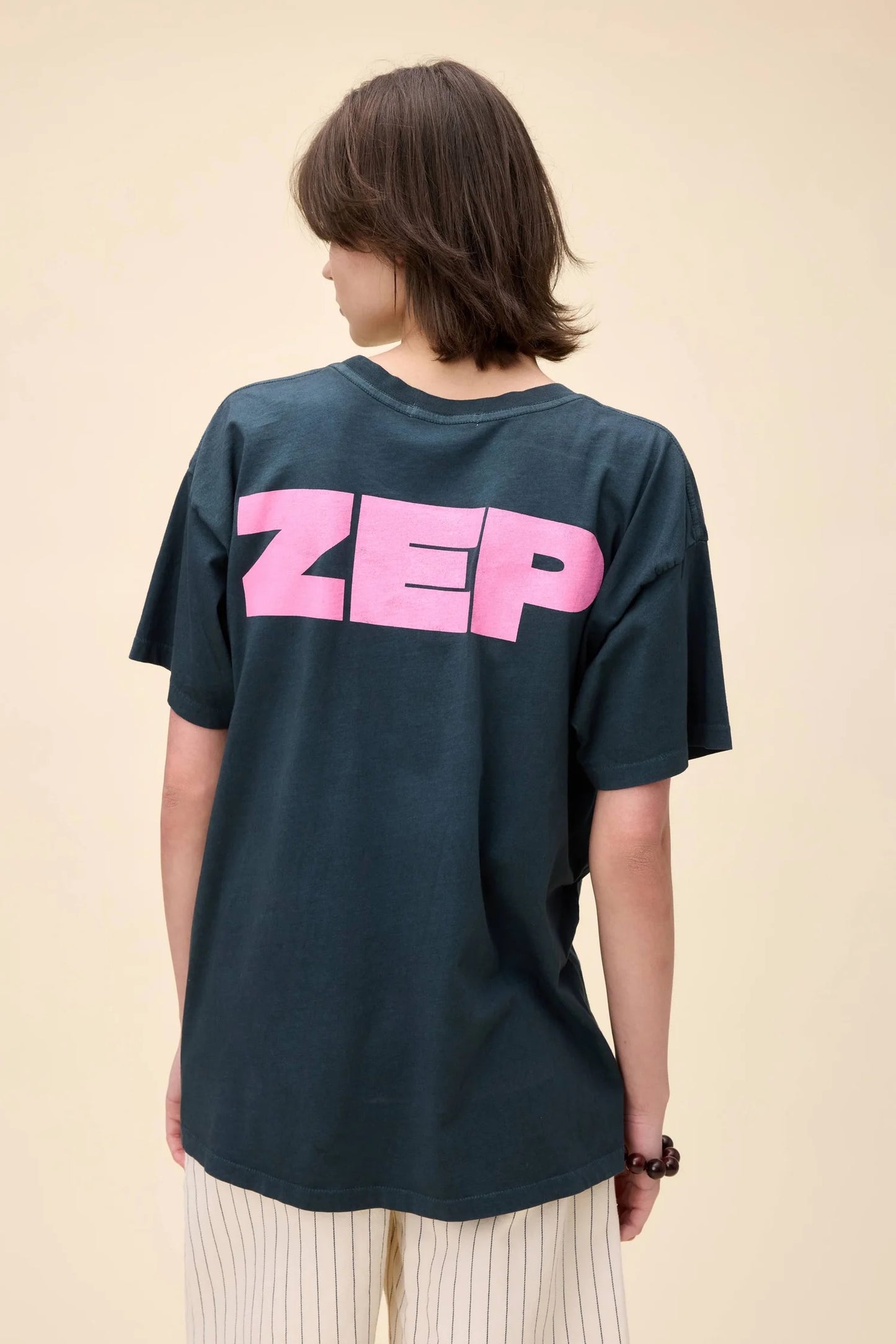 Model showcasing the back of the Led Zeppelin tee with bold "ZEP" text in pink, completing the full "LED ZEP" design.