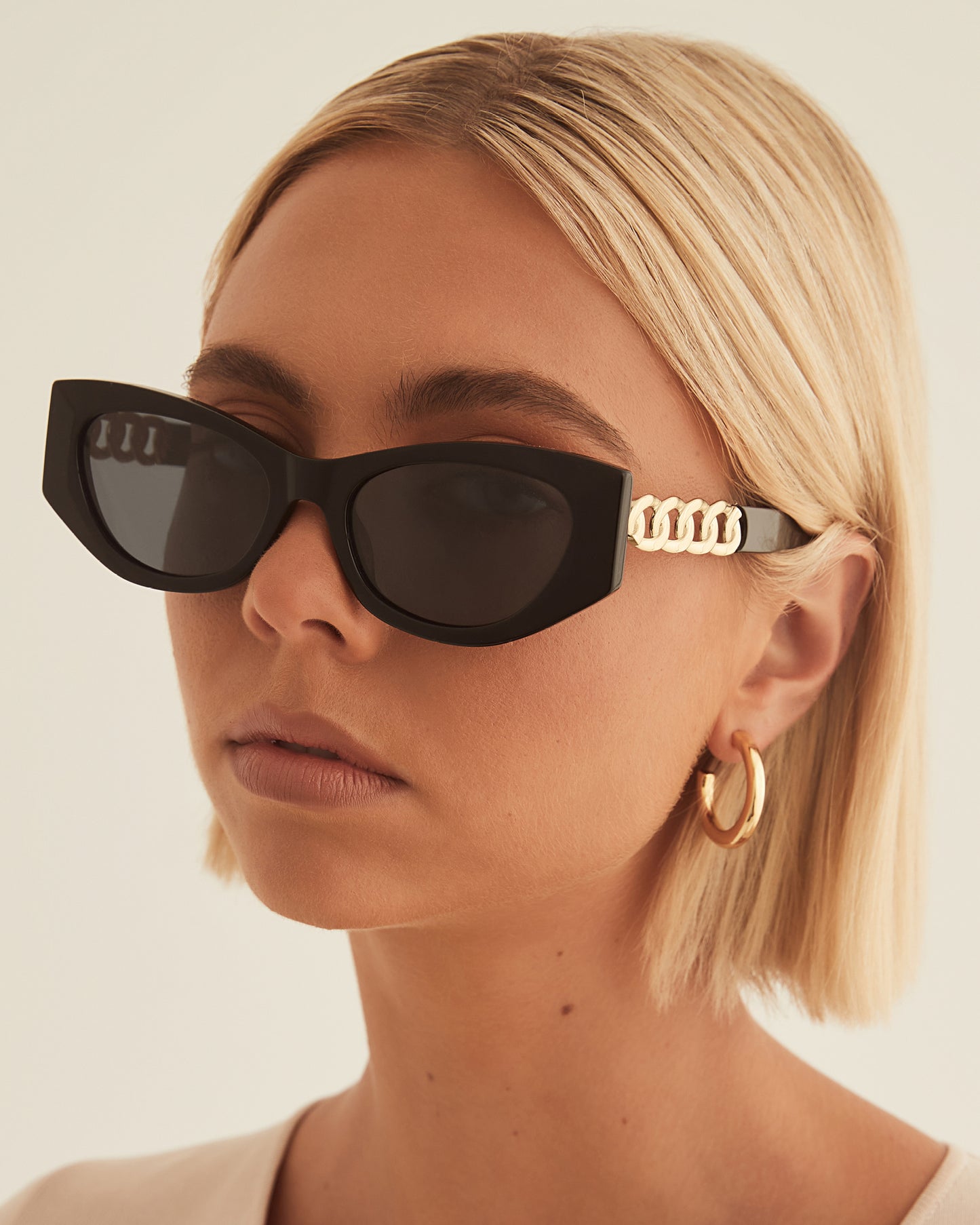 Black classic acetate cat eye sunglasses . Exude retro glamour with these fashionable cat eye sunglasses, finished with a statement chain and link feature on the arms.