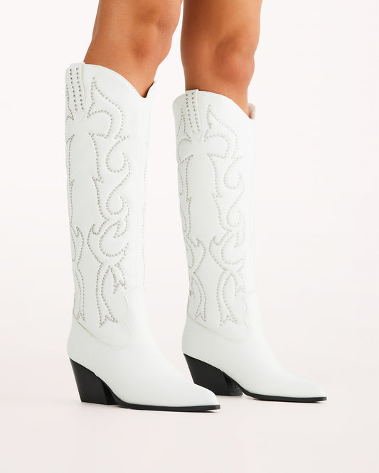Chic and bold, these white western knee-high boots feature classic cowboy stitching with silver stud embellishments, a pointed toe, and a stacked angled heel. Perfect for country concerts, bachelorette parties, festivals, or trendy street style looks.