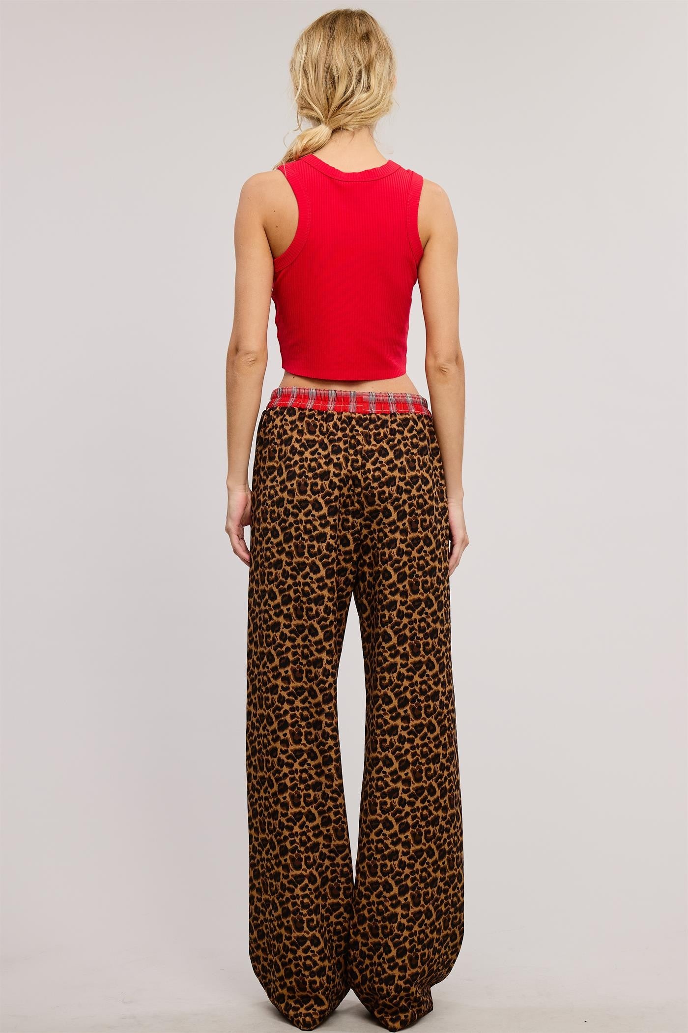 Bold and cozy, these leopard print lounge pants feature a relaxed, wide-leg fit with a contrasting red plaid elastic waistband and button fly detail. Made from soft, breathable fabric, these stylish pajama pants offer the perfect mix of comfort and statement-making fashion.