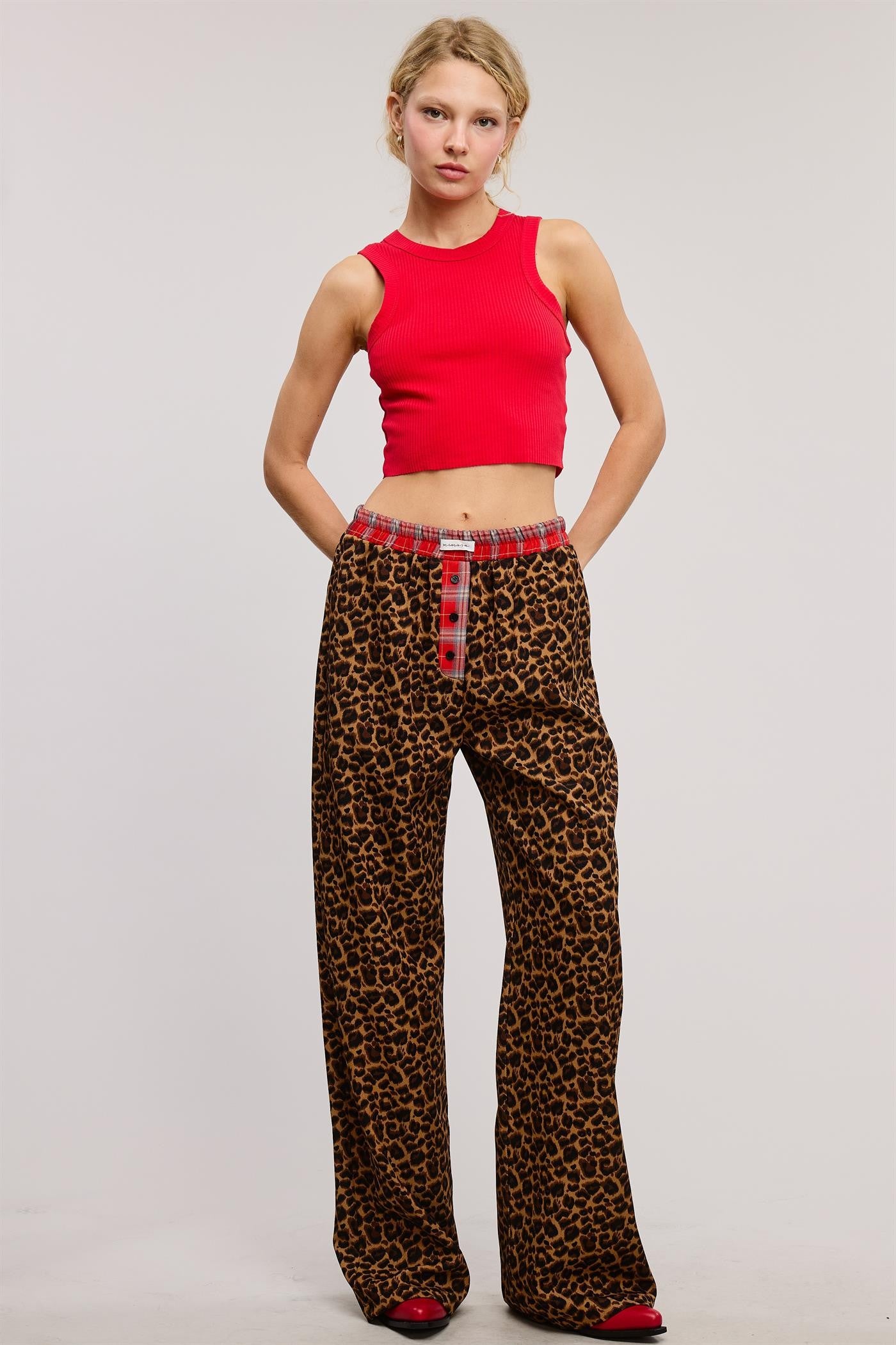 Bold and cozy, these leopard print lounge pants feature a relaxed, wide-leg fit with a contrasting red plaid elastic waistband and button fly detail. Made from soft, breathable fabric, these stylish pajama pants offer the perfect mix of comfort and statement-making fashion.