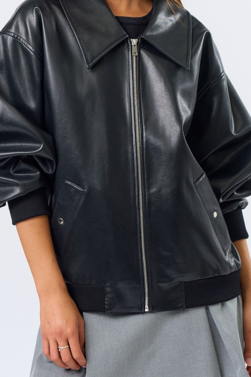 Black leather jacket worn by a person on a white background