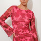 Woman wearing a pink floral dress against a white background