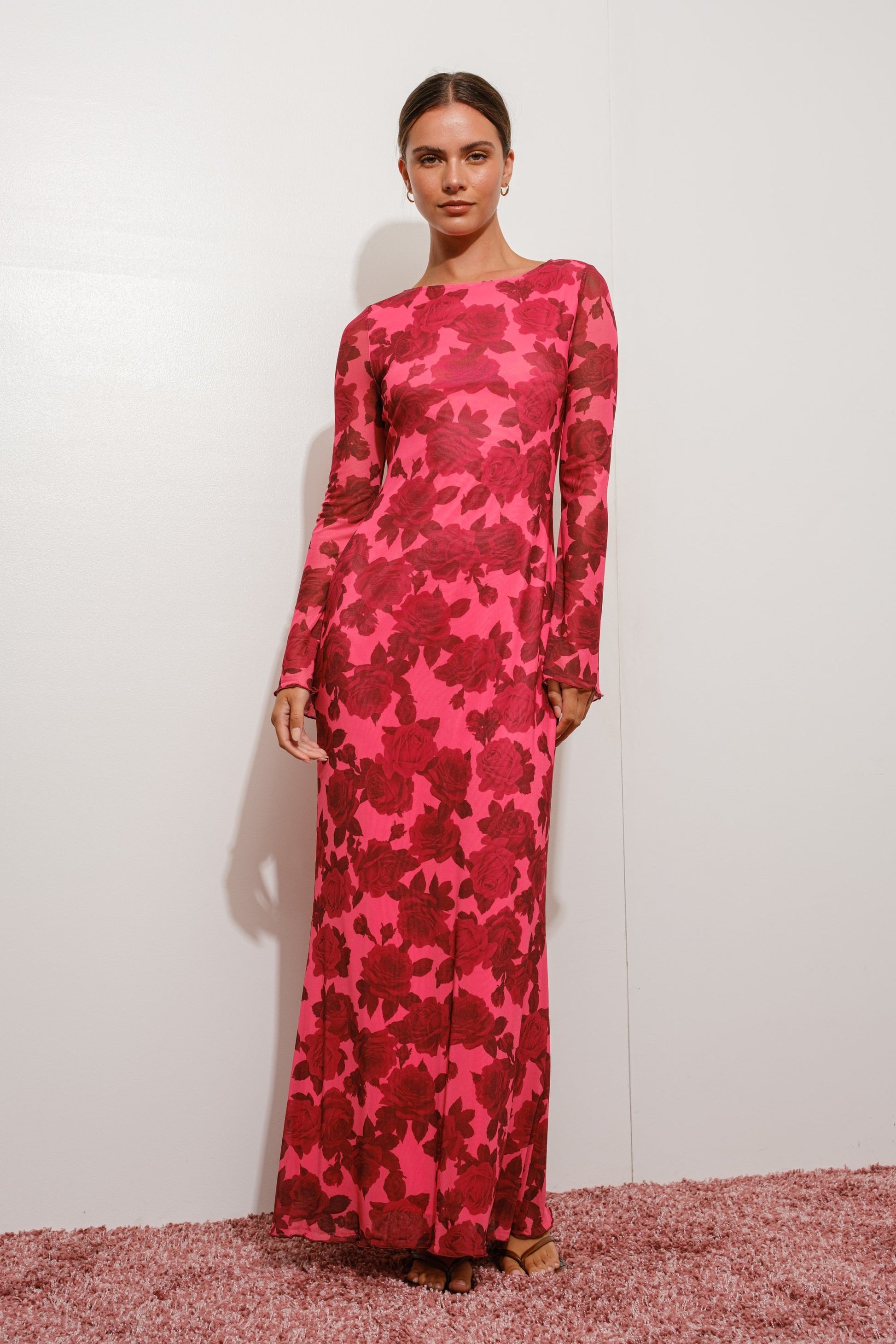 Model wearing a pink floral dress against a white background