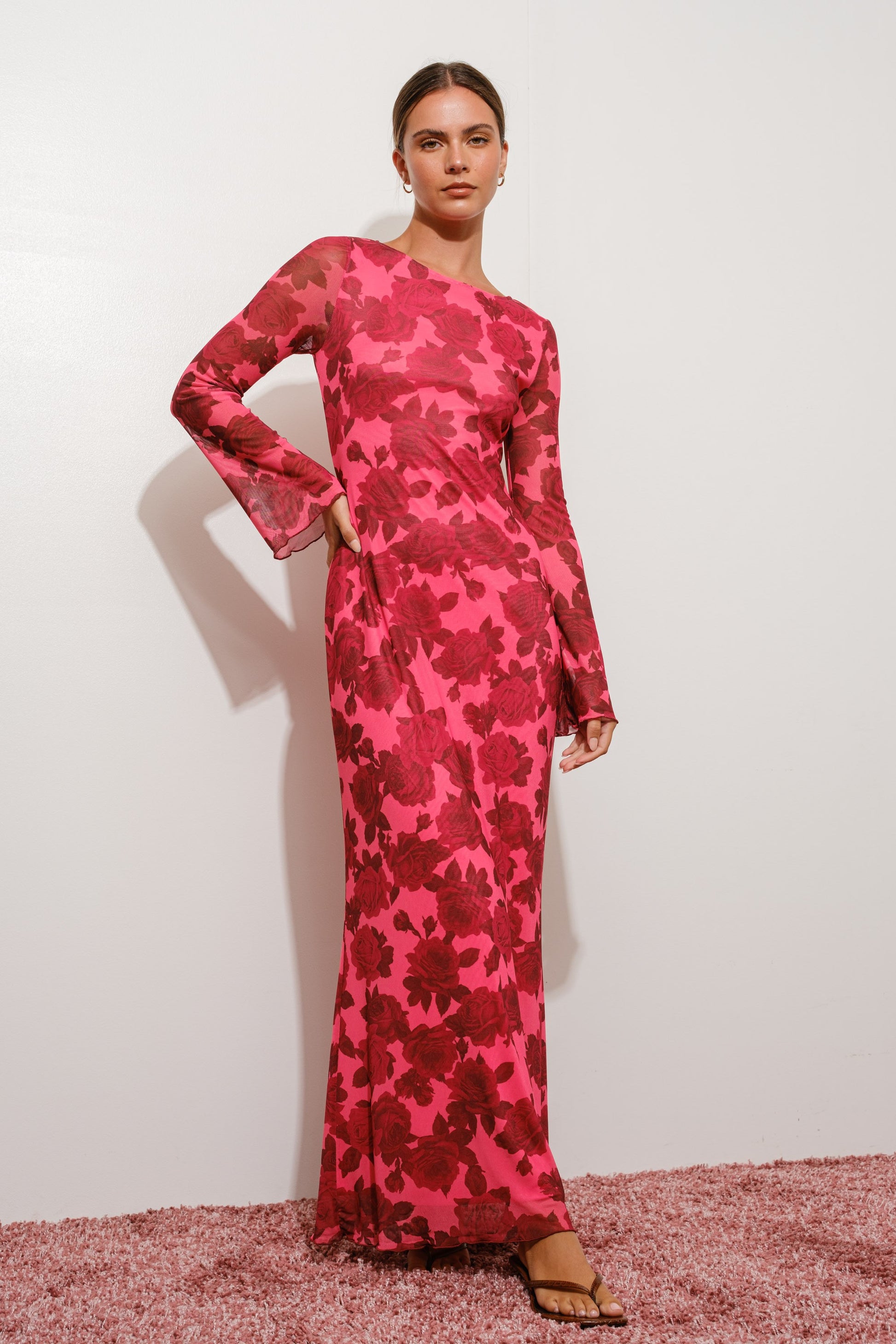 Woman wearing a pink floral dress on a white background
