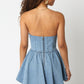 Back view of the denim mini dress showing a center zipper closure and flared hem.