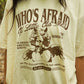 Beige t-shirt with graphic design and text worn by a person outdoors