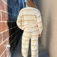 Person wearing a striped outfit walking between two walls.