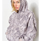 Person wearing a gray camouflage-patterned poncho against a white background