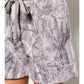 Gray patterned shorts worn by a person on a neutral background