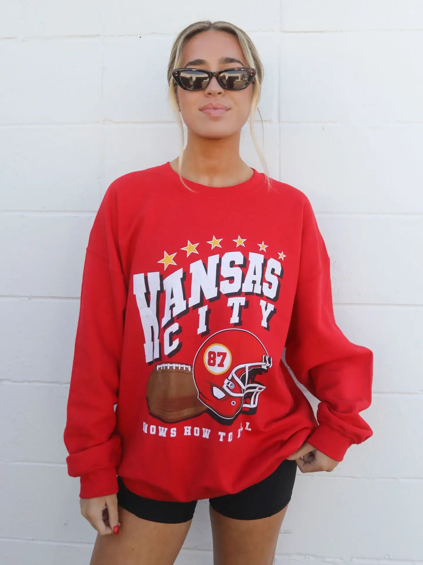 red sweatshirt with Kansas city knows how to ball on the front with a football and red helmet with 87 on helmet