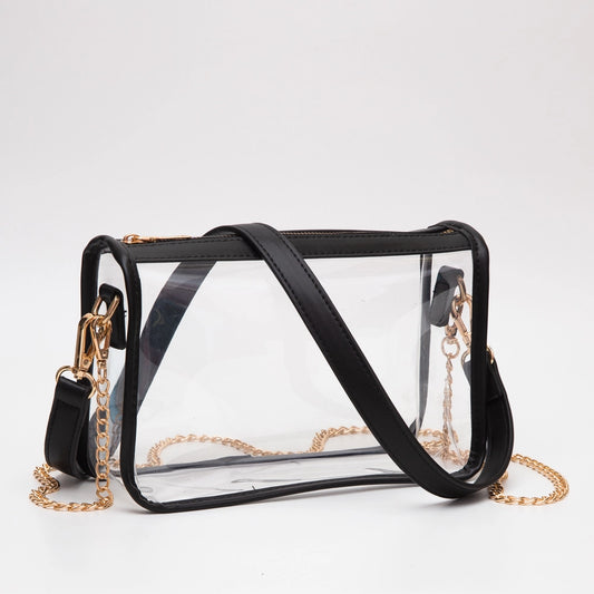 Clear handbag with black straps and gold chains on a white background