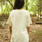 Person wearing a white oversized shirt in a forest setting