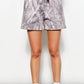 Person wearing gray patterned shorts on a white background
