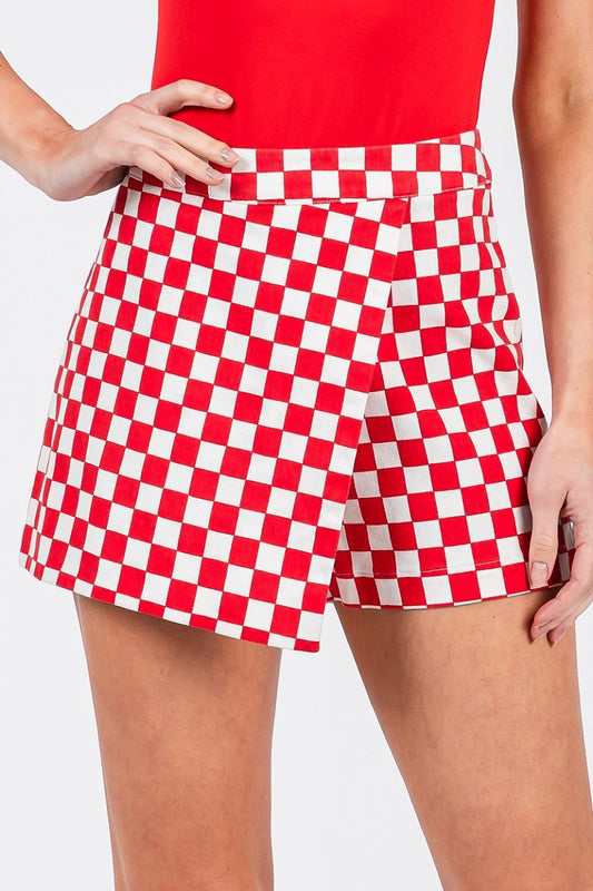 Red and white checkered shorts worn by a person on a plain background