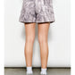 Person wearing patterned shorts on a plain background