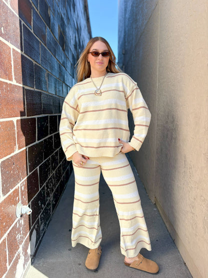 Person wearing a striped outfit standing in an alleyway.