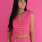 Woman wearing a pink checkered outfit against a pink background