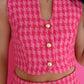 Person wearing a pink houndstooth patterned outfit with buttons on a pink background