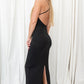 Black, slinky material maxi dress with a slit in the back.