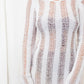 Long sleeved, sheer crochet mini dress with an open back in white.
