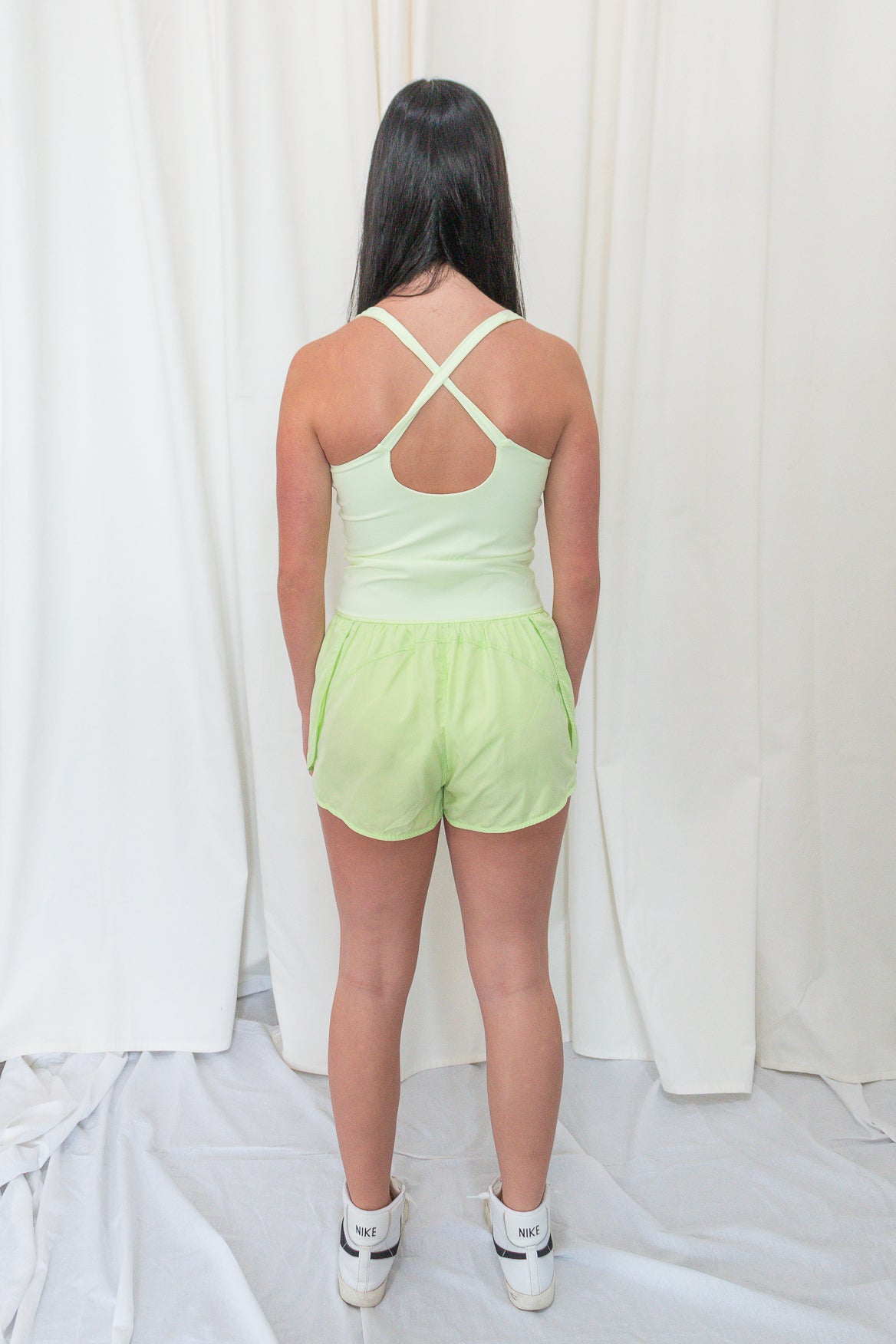 Lime green romper with elastic waistband, and small center cutout detail. 