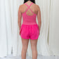 Pink romper with elastic waistband, and small center cutout detail. 