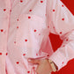 Pink shirt with red heart patterns on a red background