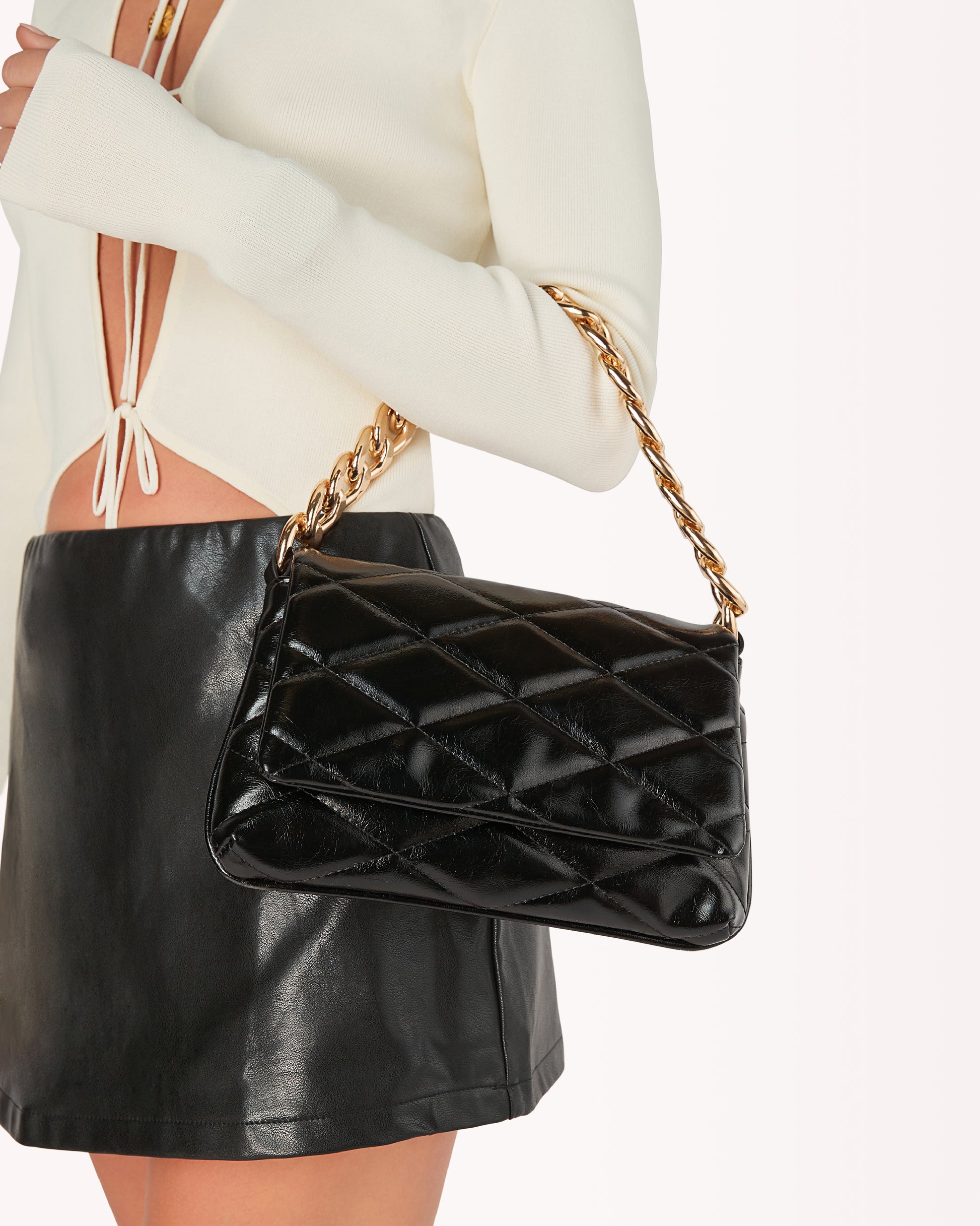 Black quilter shoulder bag with a gold chain strap