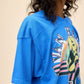 Model wearing an oversized blue Van Halen 1984 graphic tour tee featuring a bold retro design on the front and concert tour stops listed on the back.