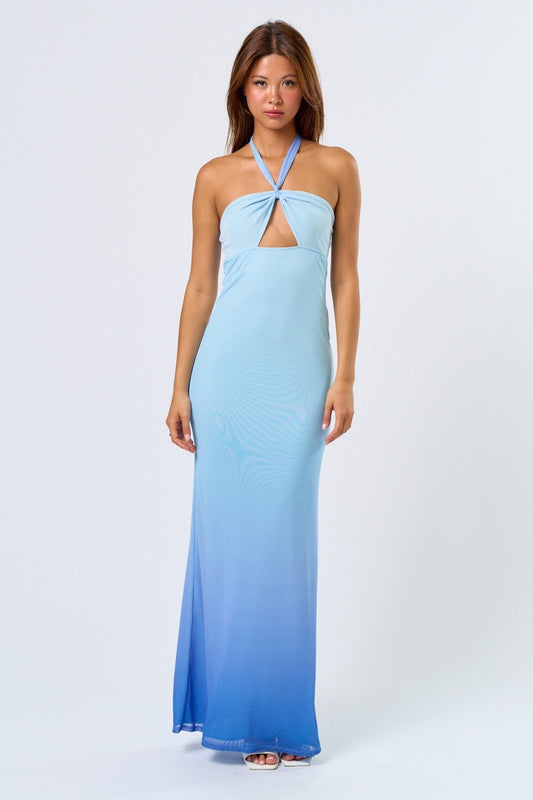 Woman wearing a blue ombré halter maxi dress with front cutout, standing against a plain white background.