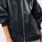 Black leather jacket worn by a person on a white background