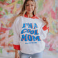 white corded sweatshirt with "im a cool mom most of the time" on the front
